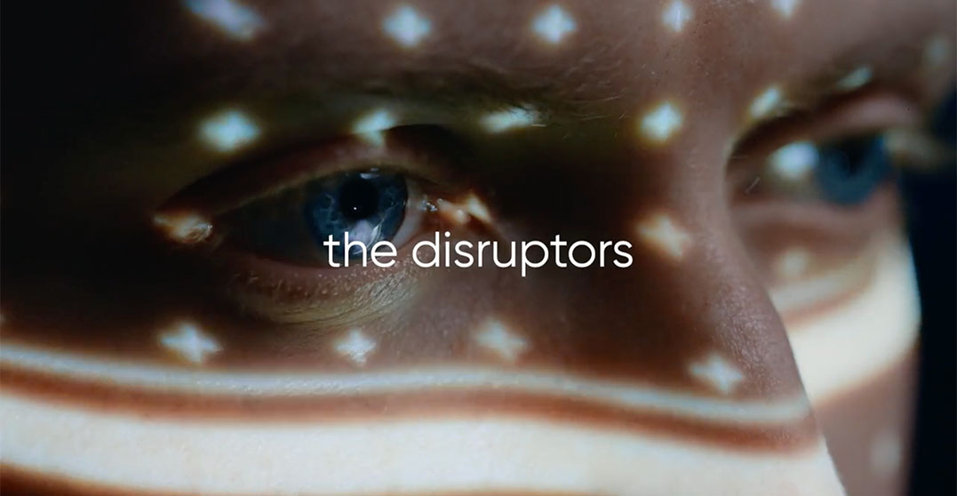 A screengrab from a video shows a close up of someones eye and the words 'the disruptors'